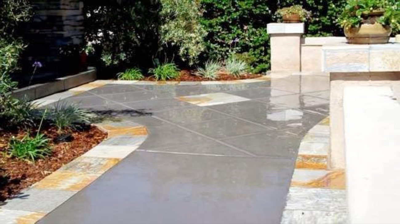 Decorative concrete walkway with natural stone borders by Residential Concrete & Design San Diego